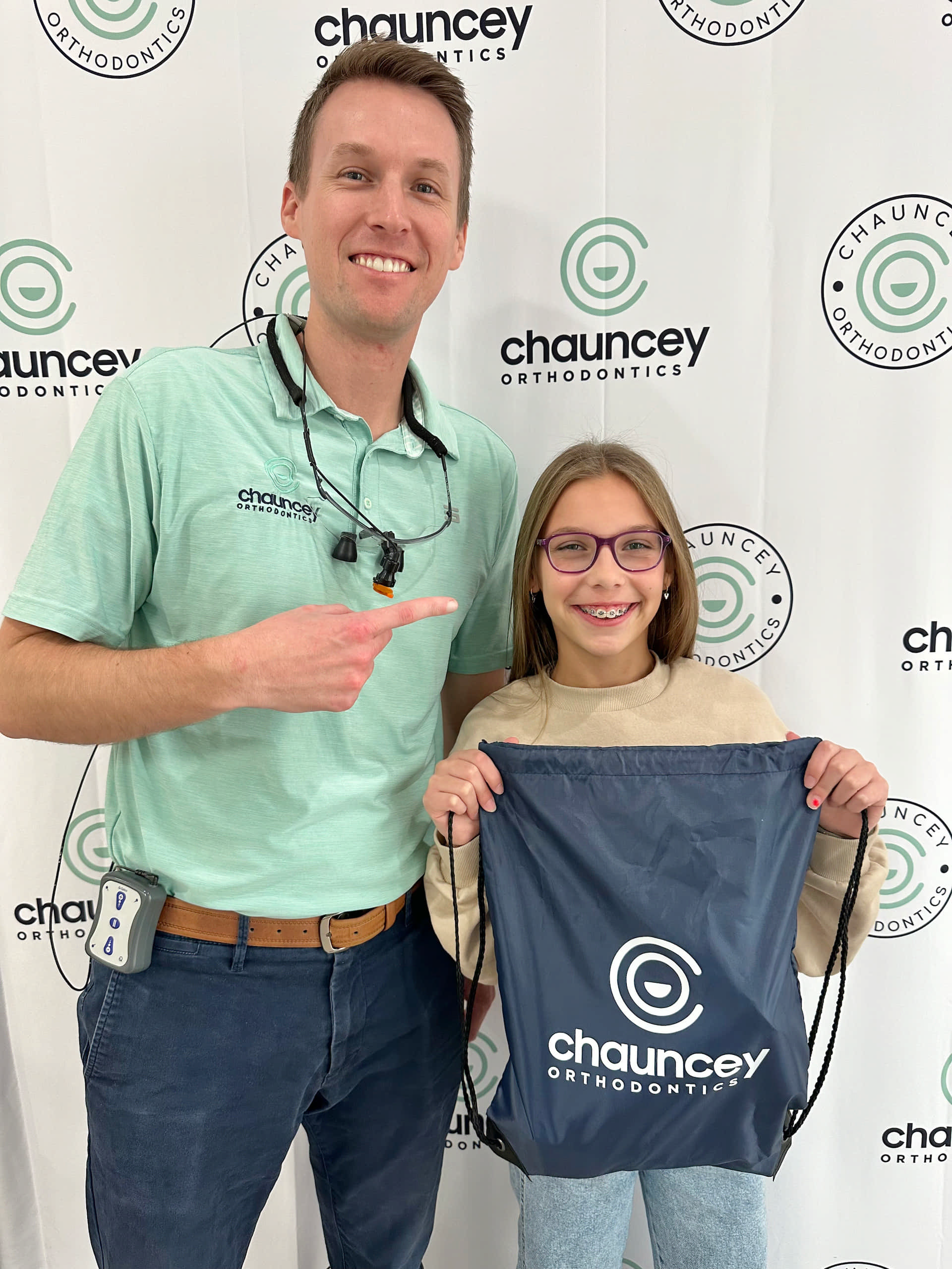 Dr. Tate Chauncey and a young girl wearing braces stand in front of a Chauncey Orthodontics in Henderson NV.